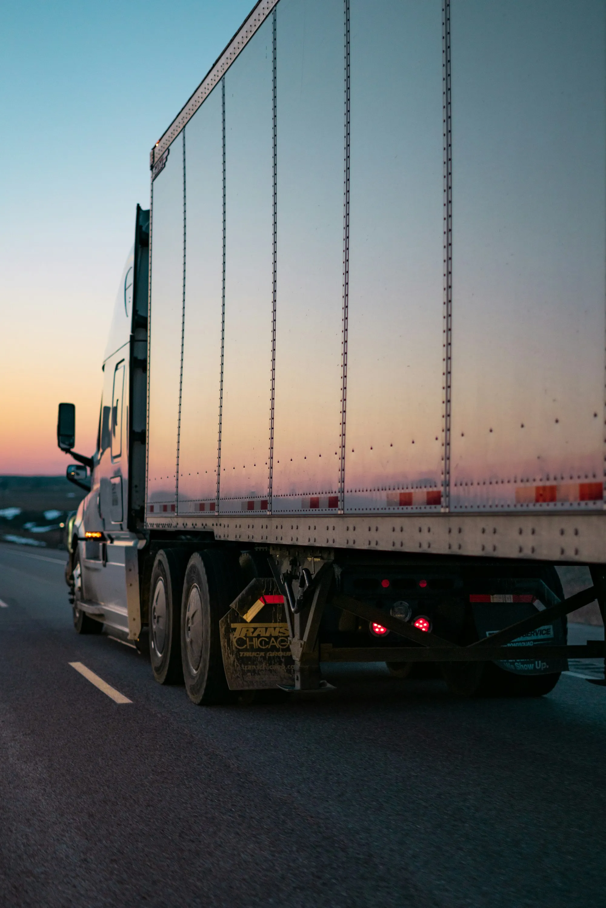 A dry van trailer rolling down the highway at dusk